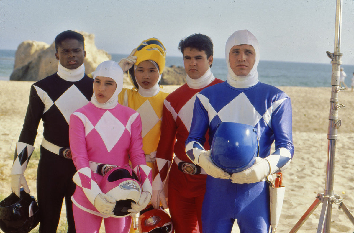 Power Rangers cast waiting on the beach during blocking with film equipment visible, behind-the-scenes photo hand-signed by Austin St. John